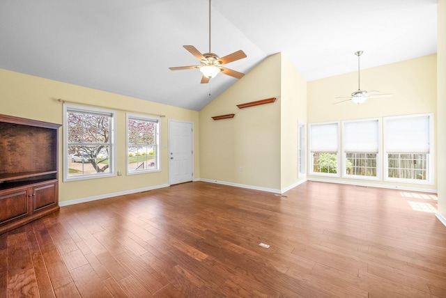 unfurnished living room with high vaulted ceiling, ceiling fan, baseboards, and wood finished floors