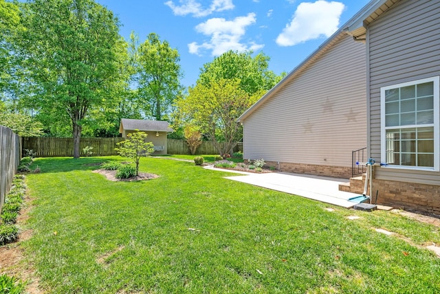 view of yard featuring an outdoor structure, a storage unit, a patio, and a fenced backyard