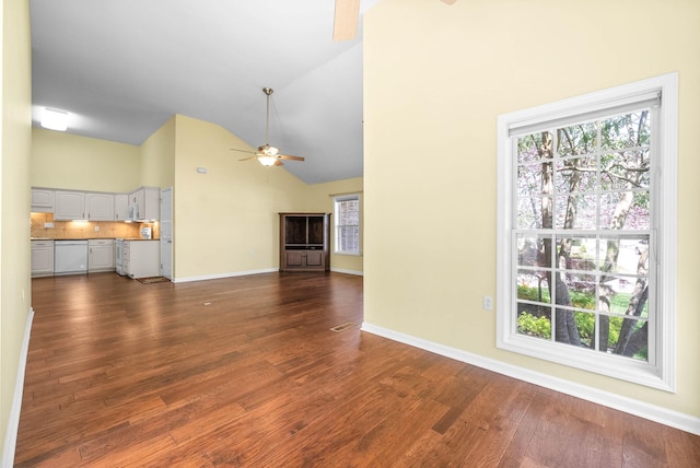 unfurnished living room with high vaulted ceiling, baseboards, a ceiling fan, and dark wood-style floors