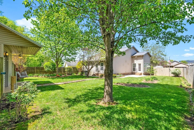 view of yard featuring a fenced backyard, a patio, and french doors