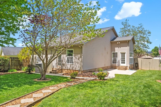 back of property featuring a fenced backyard, a gate, entry steps, a patio area, and a yard