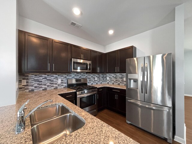 7007 Berkswell Dr, Lebanon, TN 37087 - kitchen with dark brown cabinets, a sink, appliances with stainless steel finishes, light stone countertops, and dark wood-style floors