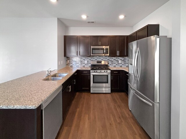 7007 Berkswell Dr, Lebanon, TN 37087 - kitchen with a peninsula, a sink, dark wood finished floors, dark brown cabinets, and appliances with stainless steel finishes