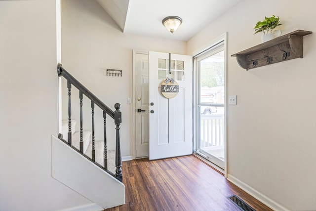 entrance foyer with wood finished floors, baseboards, and stairway