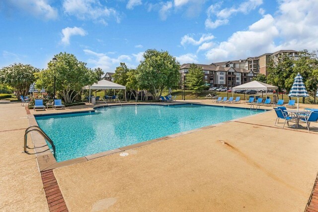 pool with a patio, a gazebo, and fence