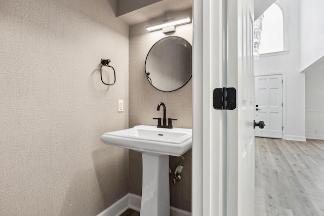 bathroom with a sink, wood finished floors, and baseboards