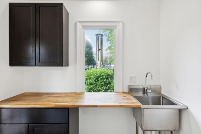 interior space featuring dark brown cabinets, wood counters, a wealth of natural light, and a sink