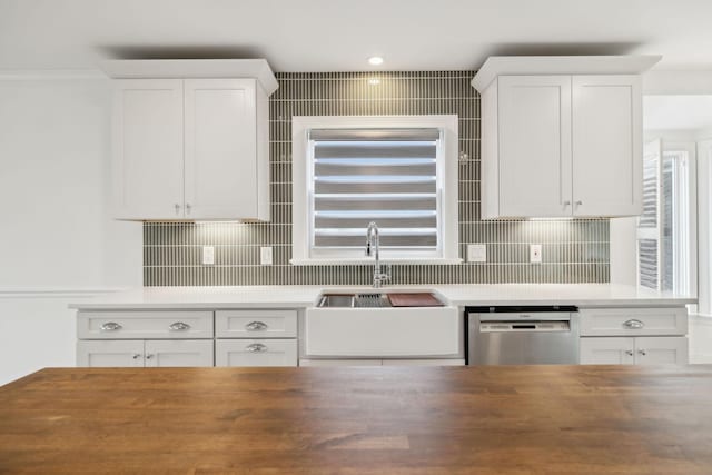kitchen with stainless steel dishwasher, butcher block counters, white cabinets, and decorative backsplash
