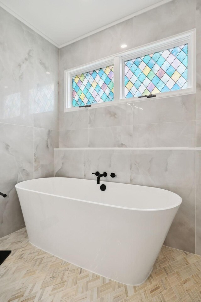 full bathroom with a freestanding tub and tile walls