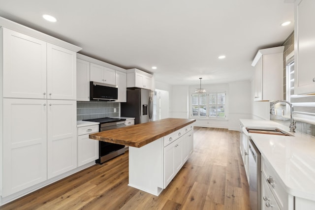 kitchen featuring wooden counters, white cabinets, light wood-style flooring, and stainless steel appliances
