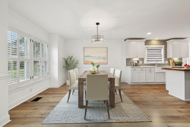 dining space featuring light wood-style flooring, visible vents, baseboards, recessed lighting, and a notable chandelier