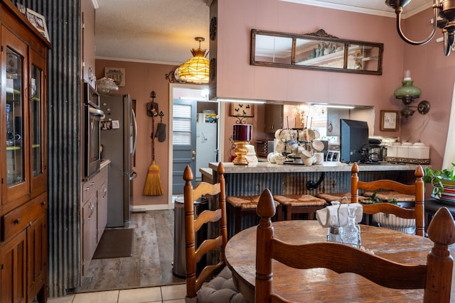 60 Sam Johnson Ln, Scotts Hill, TN 38374 - dining space featuring light tile patterned flooring, a textured ceiling, and crown molding