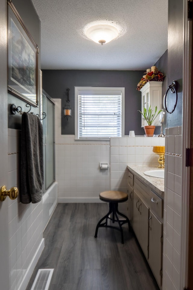 60 Sam Johnson Ln, Scotts Hill, TN 38374 - full bath with enclosed tub / shower combo, wood finished floors, a textured ceiling, and tile walls