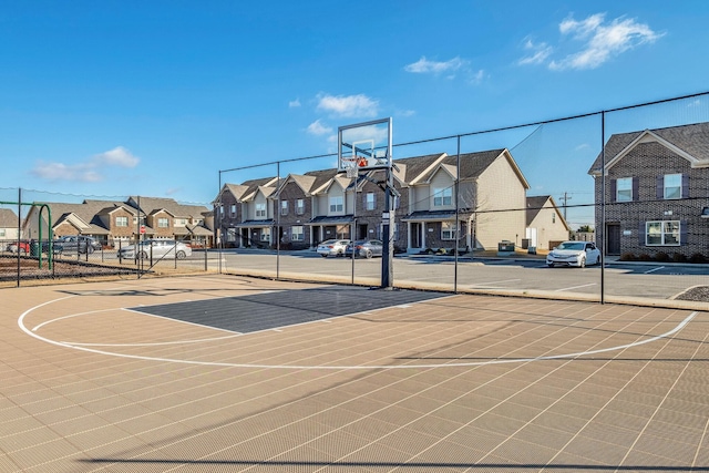 view of sport court with community basketball court, fence, and a residential view