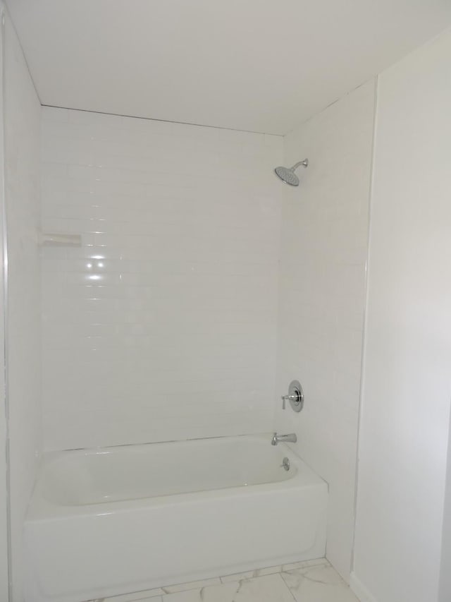 full bathroom featuring marble finish floor and shower / tub combination