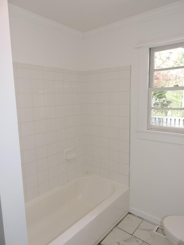 bathroom featuring baseboards, marble finish floor, ornamental molding, and toilet