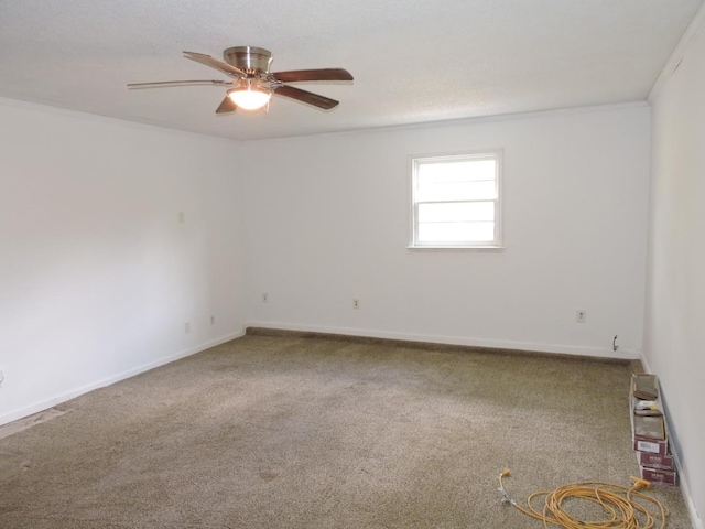 spare room featuring baseboards, carpet, ceiling fan, and crown molding