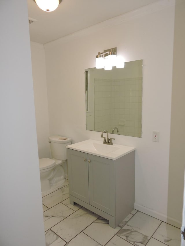 bathroom with marble finish floor, toilet, and vanity