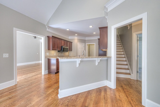 1178 Mccoury Ln, Spring Hill, TN 37174 - kitchen with crown molding, a peninsula, light wood-style floors, a kitchen breakfast bar, and tasteful backsplash