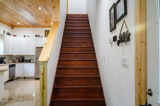 stairs with recessed lighting, wood ceiling, a textured wall, and tile patterned floors