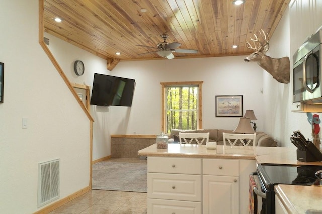 kitchen with light tile patterned flooring, recessed lighting, stainless steel microwave, visible vents, and wood ceiling