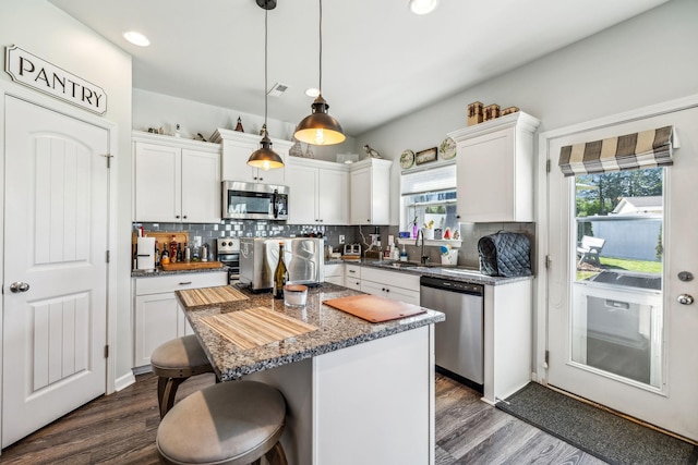 kitchen with stainless steel appliances, a sink, white cabinetry, and dark wood finished floors