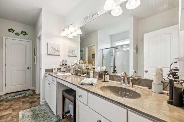 full bath featuring double vanity, a stall shower, and a sink