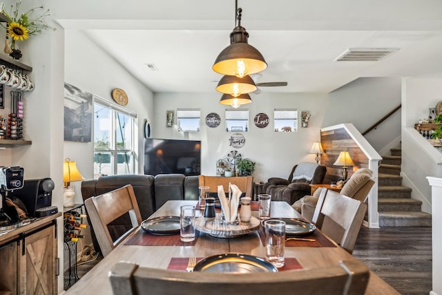 dining room featuring stairway, wood finished floors, visible vents, and plenty of natural light