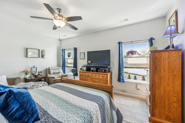 carpeted bedroom featuring baseboards, a ceiling fan, and visible vents