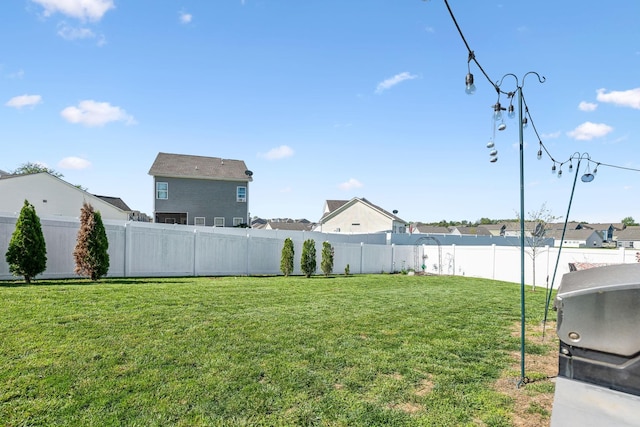 view of yard with a fenced backyard and a residential view