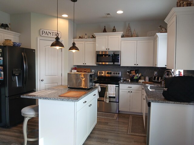 kitchen featuring a center island, dark wood-style floors, a sink, and appliances with stainless steel finishes