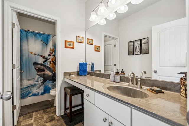 full bathroom with vanity, stone finish floor, a shower with shower curtain, and toilet