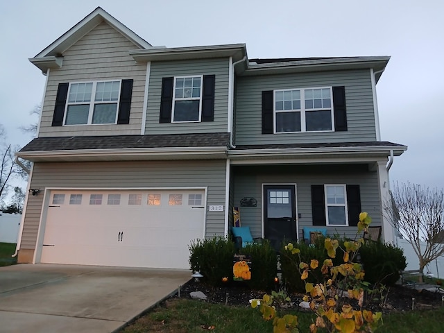 view of front of house featuring an attached garage, driveway, and covered porch