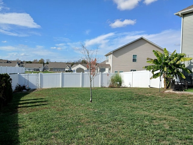 view of yard featuring a fenced backyard and a residential view