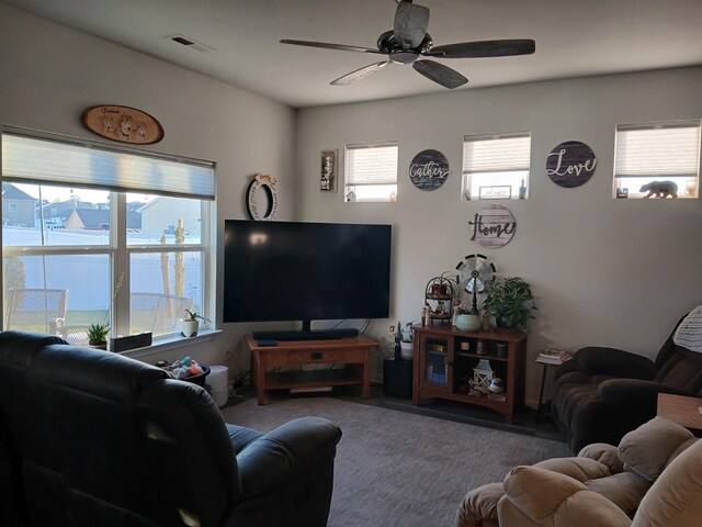 living area featuring plenty of natural light, visible vents, and ceiling fan