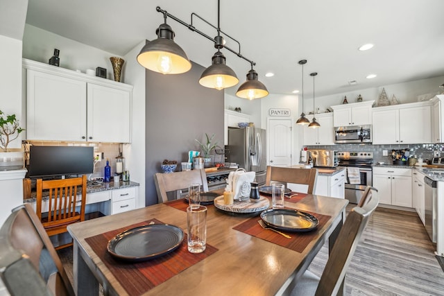 dining area featuring wood finished floors and recessed lighting