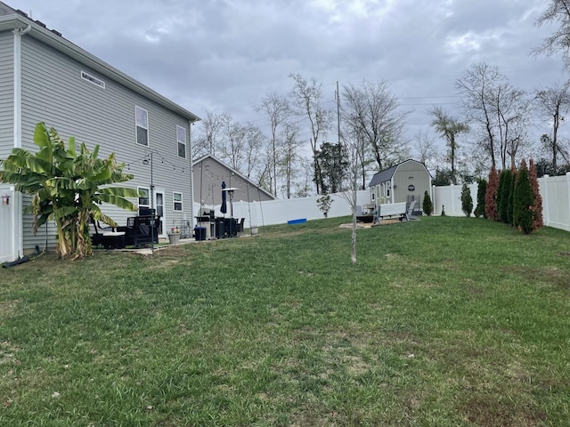 view of yard with an outbuilding, a shed, a fenced backyard, and central AC unit