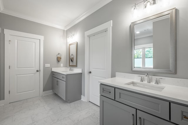 full bathroom featuring marble finish floor, two vanities, ornamental molding, and a sink