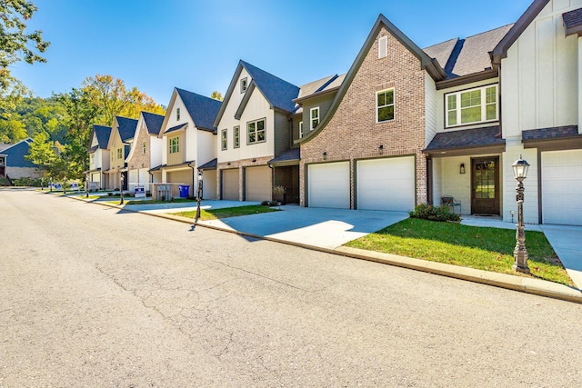 view of property featuring a residential view, board and batten siding, driveway, brick siding, and a garage