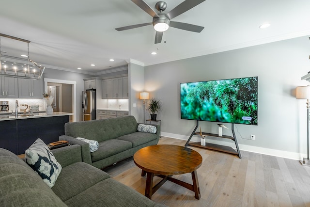 living area featuring a ceiling fan, crown molding, light wood-type flooring, baseboards, and recessed lighting