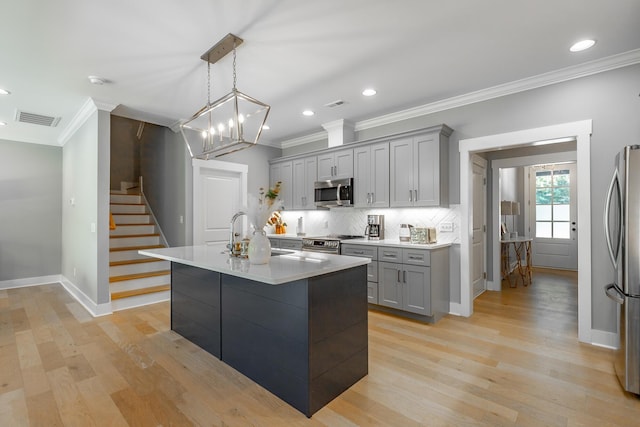 kitchen featuring ornamental molding, appliances with stainless steel finishes, gray cabinetry, and visible vents