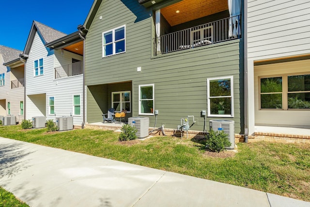 rear view of property featuring cooling unit, a patio area, and a balcony