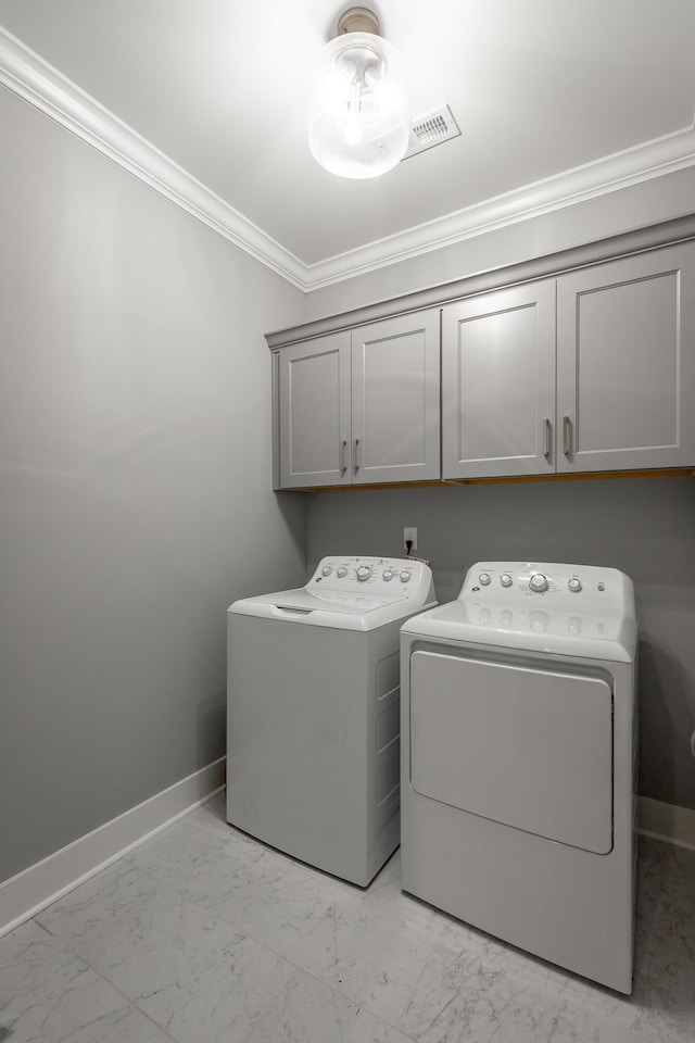 washroom featuring marble finish floor, cabinet space, baseboards, ornamental molding, and independent washer and dryer