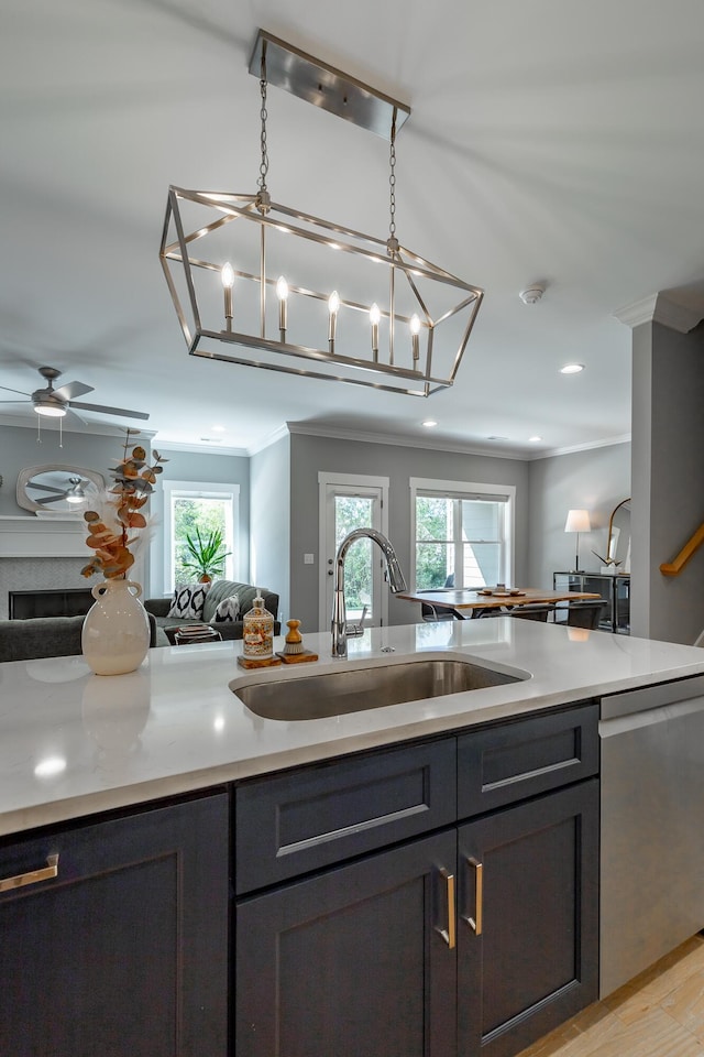kitchen featuring open floor plan, stainless steel dishwasher, a sink, and ornamental molding