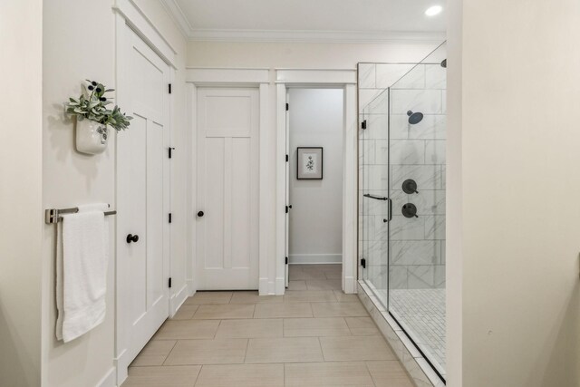 bathroom with baseboards, crown molding, tile patterned flooring, and a stall shower