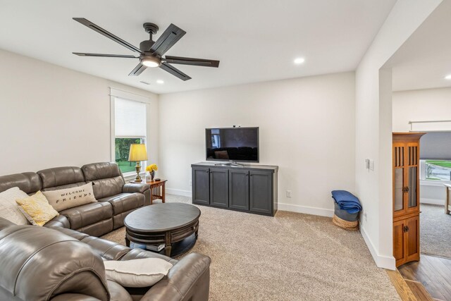 living room featuring plenty of natural light, a ceiling fan, and baseboards