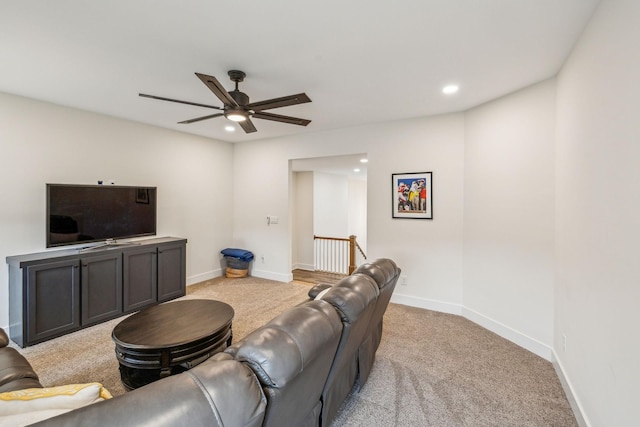 living room featuring baseboards, light carpet, a ceiling fan, and recessed lighting