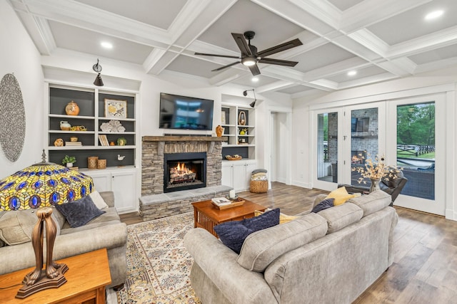 living room featuring coffered ceiling, wood finished floors, beamed ceiling, a fireplace, and ceiling fan