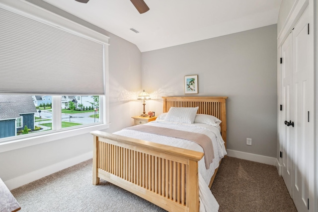 carpeted bedroom with vaulted ceiling, visible vents, a closet, baseboards, and ceiling fan