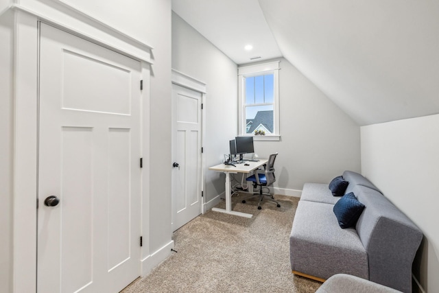 carpeted office with lofted ceiling and baseboards